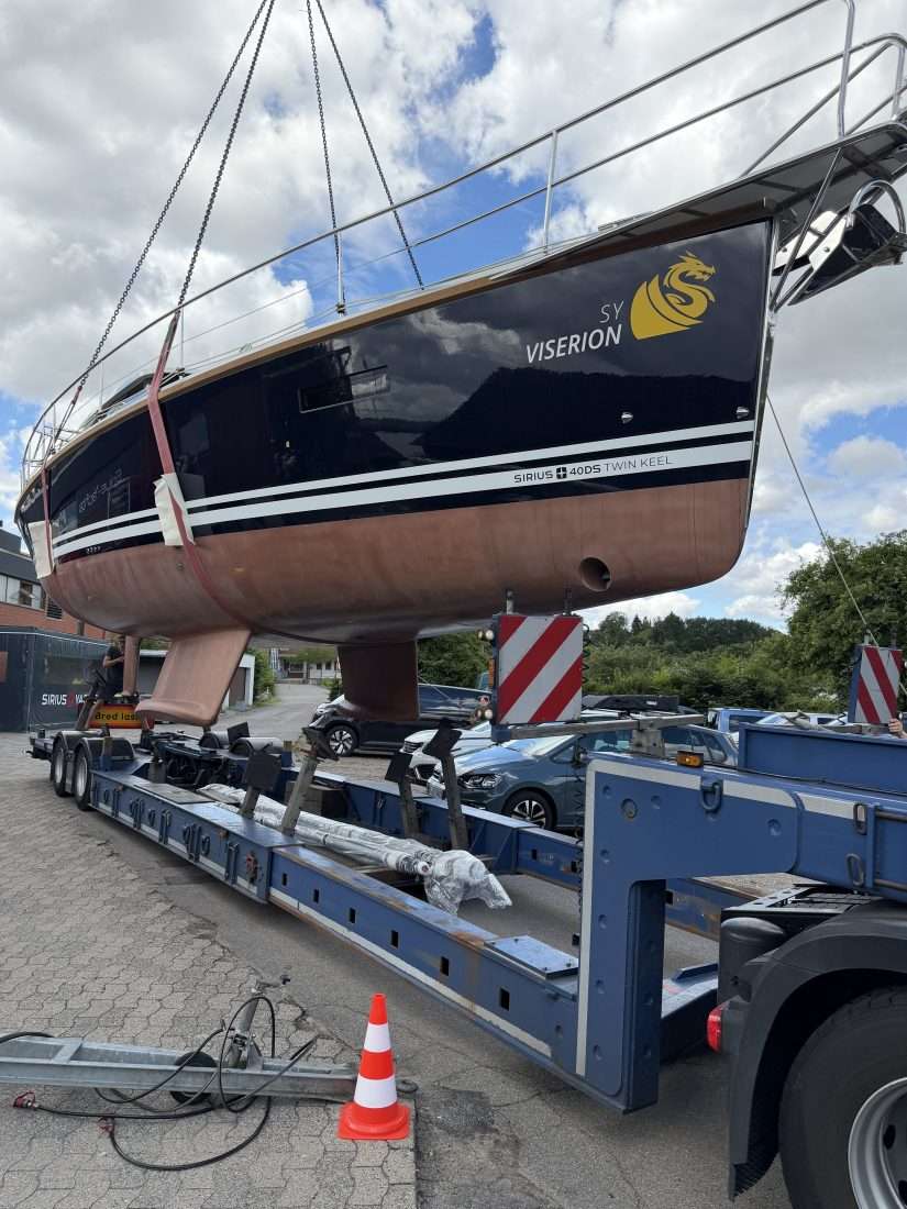 Uli mit dem Transportfahrzeug und einer verladenen Sirius vor der Werft. Seit 1996 ein vertrauter Anblick in Plön: Uli Faltus holt eine fertiggestellte Sirius für den Transport ab.